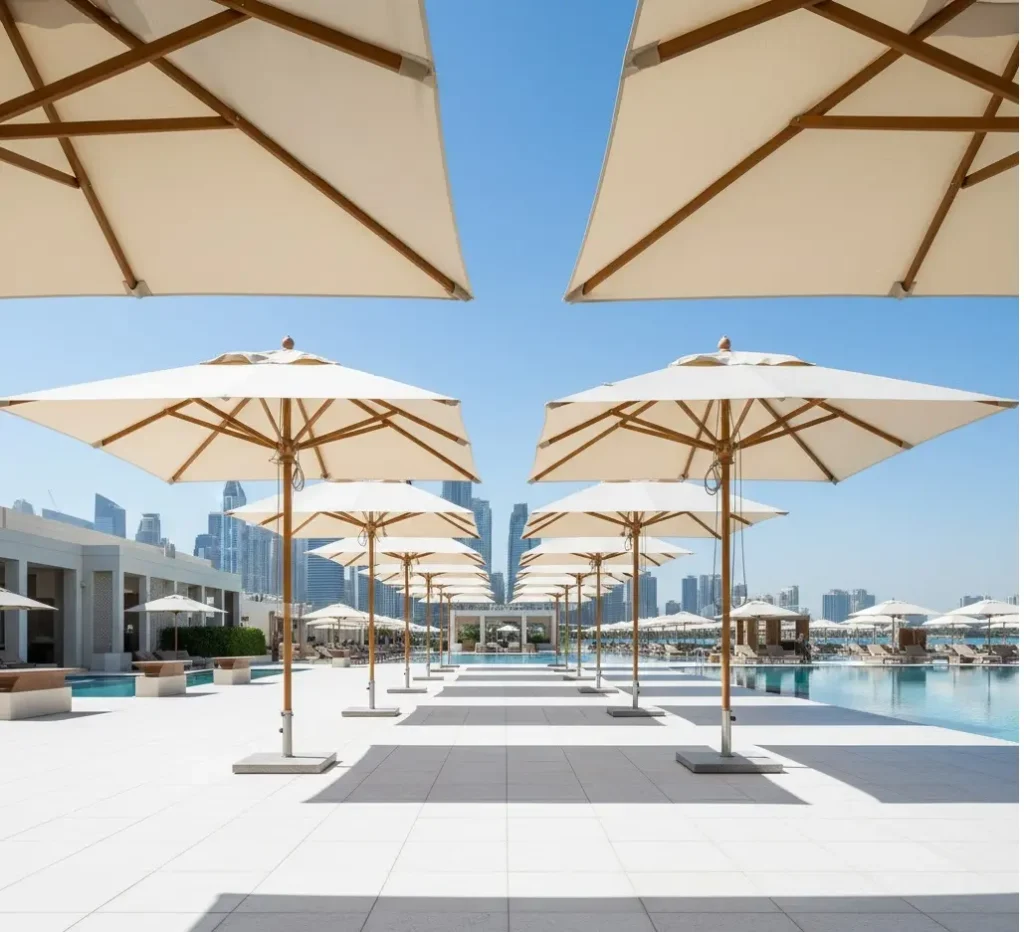 A row of heavy-duty commercial resort umbrellas with marine-grade fabric along a luxury pool deck in Dubai.